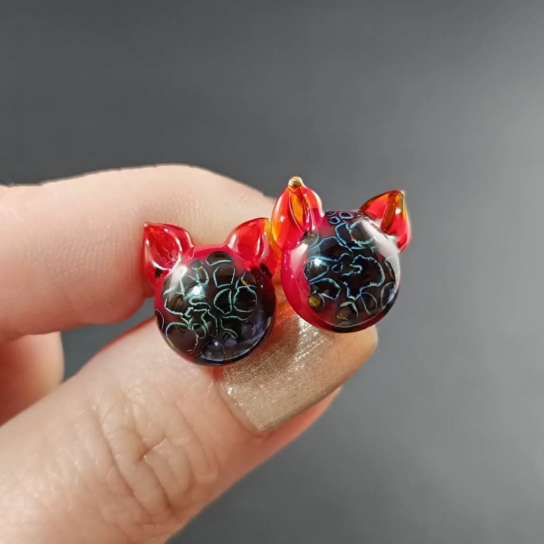 Handmade glass cat stud earrings with red ears and a starry-night interior — a unique glass jewellery gift