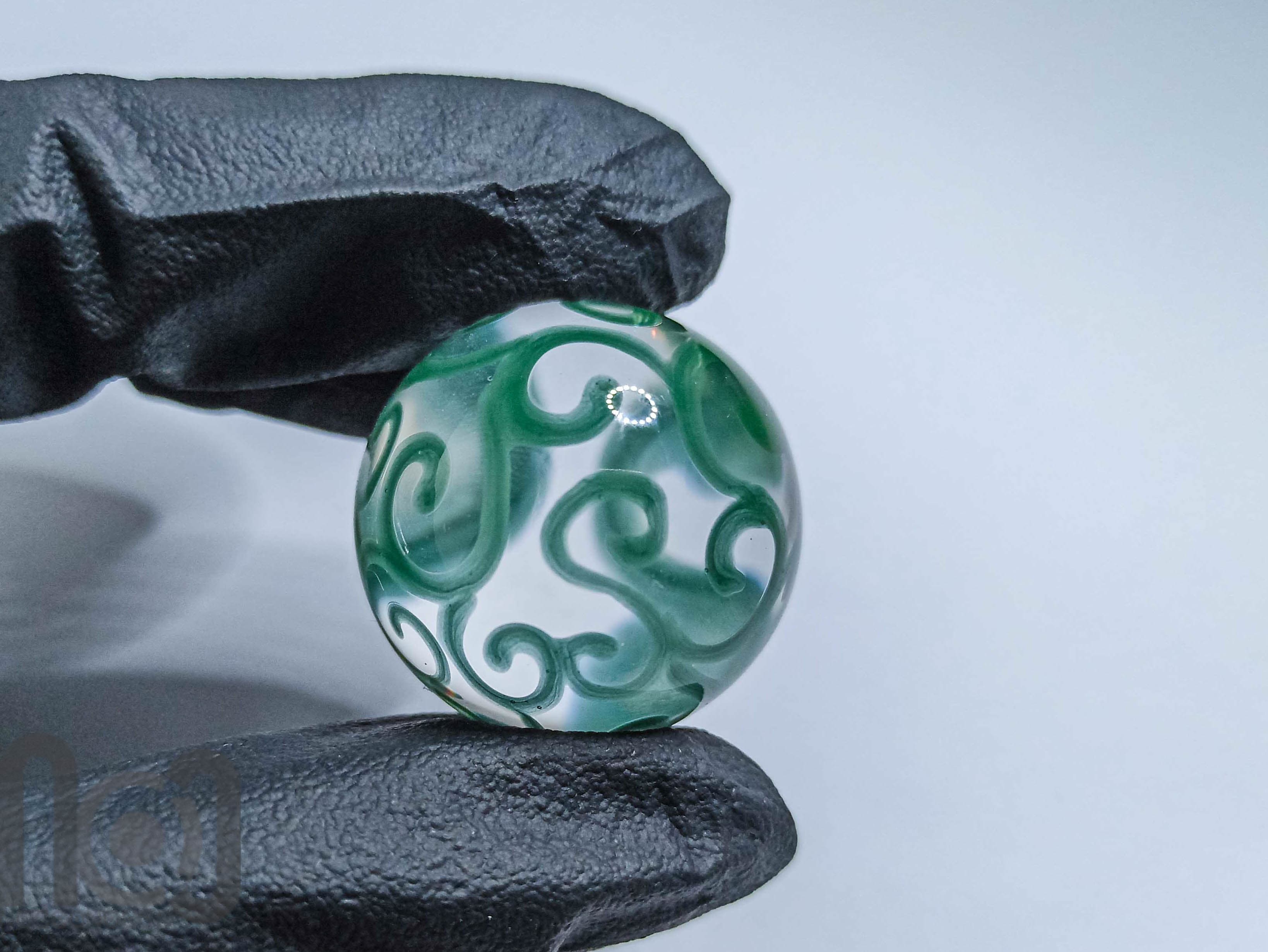 Handmade Clear Glass Marble with Green Scrolls, v127 — handmade borosilicate glass by NoccoNocco, detail view 2 of 2, made in Greece