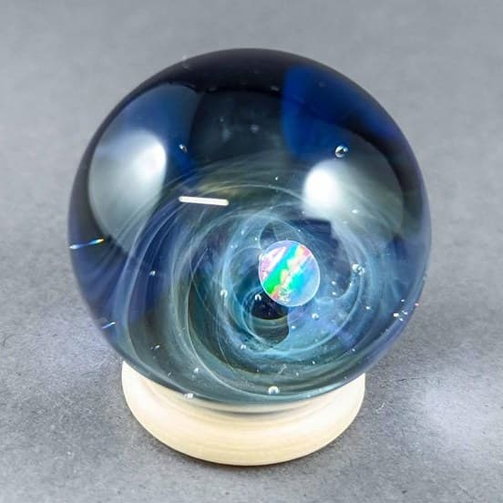 Borosilicate galaxy marble with a luminous opal planet and a decorated nebula backside