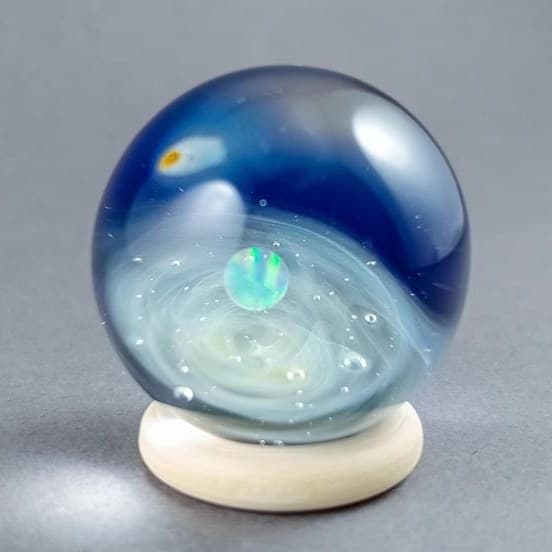 Handmade galaxy glass marble with a floating opal planet and a shooting star
