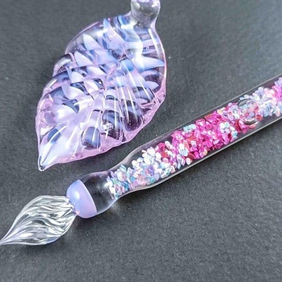 Handmade lavender glass dip pen with a glittering interior and a leaf pen rest