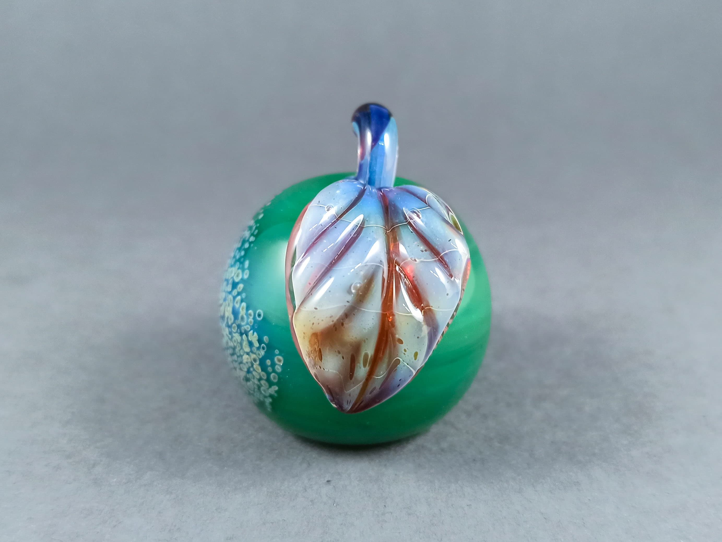 Solid Glass Apple Marble with a Leaf, v265 — handmade borosilicate glass by NoccoNocco, detail view 3 of 4, made in Greece